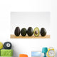 A Row Of Avocados Standing Upright On A Wooden Board With One Cut Wall Mural
