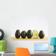 A Row Of Avocados Standing Upright On A Wooden Board With One Cut Wall Mural