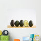 A Row Of Avocados Standing Upright On A Wooden Board With One Cut Wall Mural