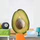Close Up Of An Avocado Standing Upright Cut In Half With The Pit Wall Mural