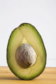 Close Up Of An Avocado Standing Upright Cut In Half With The Pit Wall Mural