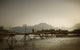 Boy Running Across A Wooden Bridge On A River With Mountains Wall Mural