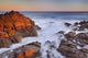 California, Malibu, Sunset over rocky ocean coastline Wall Mural