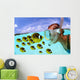 Over/under woman snorkeler face to face with Butterflyfish school Wall Mural
