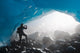 A Hiker Takes Photo Of The Entrance Of An Ice Cave Wall Mural