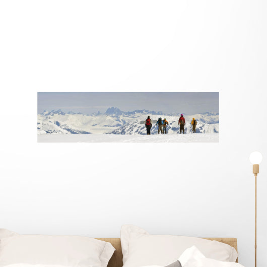 A Snowboarder And Skiers Hike Wall Mural