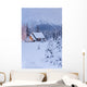 Snowcovered Home In A Wintry Meadow At Dawn With Inside Lights On Wall Mural