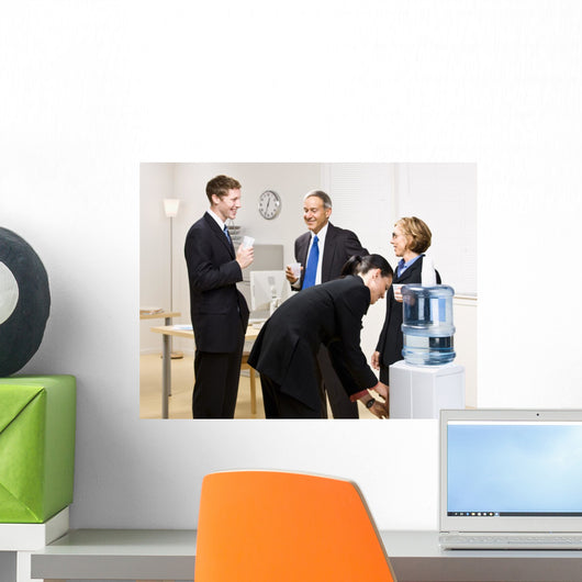 Business people drinking water at water cooler Wall Mural