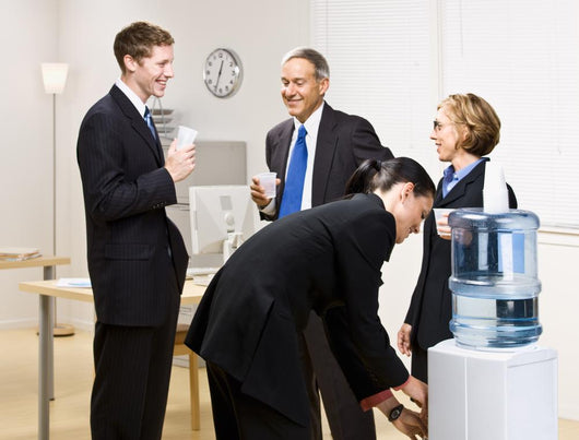 Business people drinking water at water cooler Wall Mural