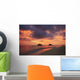 Vibrant sunset with a couple embracing on beach Wall Mural