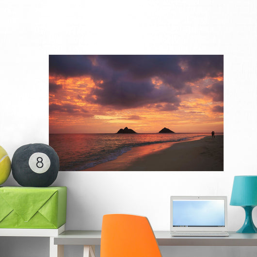 Vibrant sunset with a couple embracing on beach Wall Mural