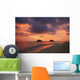 Vibrant sunset with a couple embracing on beach Wall Mural