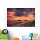 Vibrant sunset with a couple embracing on beach Wall Mural