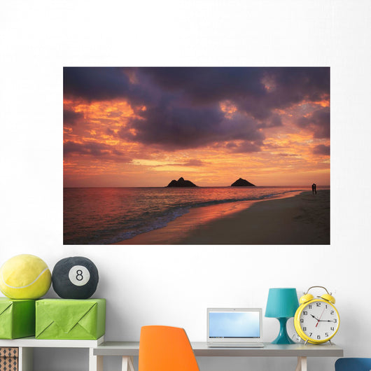 Vibrant sunset with a couple embracing on beach Wall Mural