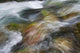 A close up of colorful river rocks under water Wall Mural