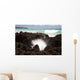 A burst of water through a blowhole in some lava rocks Wall Mural
