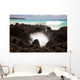 A burst of water through a blowhole in some lava rocks Wall Mural
