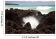 A burst of water through a blowhole in some lava rocks Wall Mural