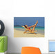 Beautiful woman stretches in a lounge chair on the beach Wall Mural