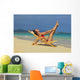 Beautiful woman stretches in a lounge chair on the beach Wall Mural