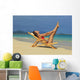 Beautiful woman stretches in a lounge chair on the beach Wall Mural