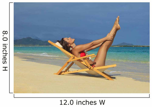 Beautiful woman stretches in a lounge chair on the beach Wall Mural