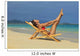 Beautiful woman stretches in a lounge chair on the beach Wall Mural