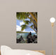 Sunny blue skies light up the lush coast with palm trees Wall Mural