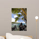 Sunny blue skies light up the lush coast with palm trees Wall Mural