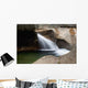 A forest riverbed and waterfall Wall Mural