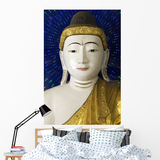 Head of a Buddha statue against blue background Wall Mural