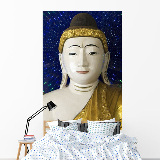 Head of a Buddha statue against blue background Wall Mural