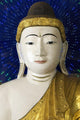 Head of a Buddha statue against blue background Wall Mural
