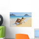 Beautiful woman lounges on a remote beach Wall Mural