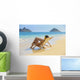 Beautiful woman lounges on a remote beach Wall Mural