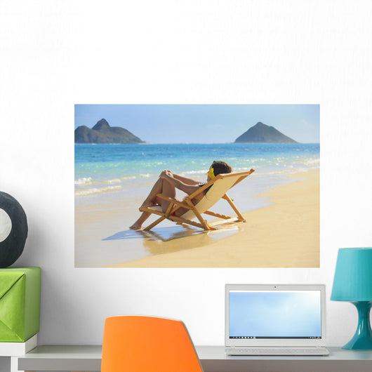 Beautiful woman lounges on a remote beach Wall Mural