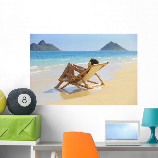 Beautiful woman lounges on a remote beach Wall Mural