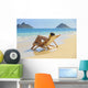 Beautiful woman lounges on a remote beach Wall Mural