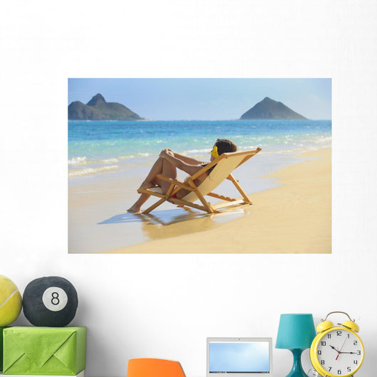 Beautiful woman lounges on a remote beach Wall Mural