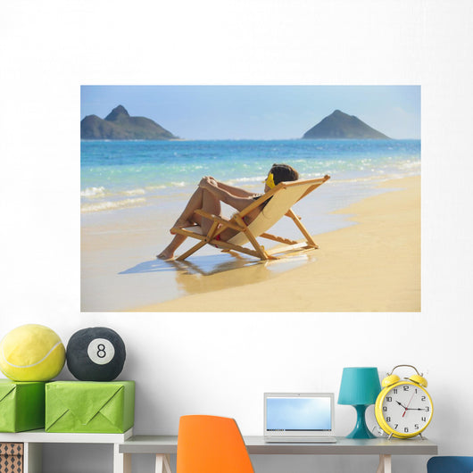 Beautiful woman lounges on a remote beach Wall Mural
