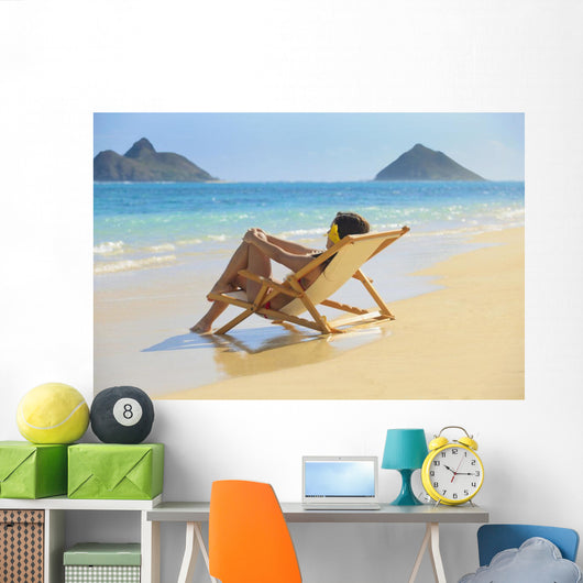 Beautiful woman lounges on a remote beach Wall Mural