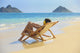 Beautiful woman lounges on a remote beach Wall Mural
