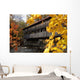 A covered bridge over a river in Autumn Wall Mural