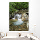 A rocky riverbed and waterfall Wall Mural