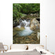 A rocky riverbed and waterfall Wall Mural