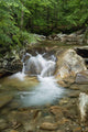 A rocky riverbed and waterfall Wall Mural