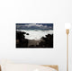 A wave breaks with lave rocks in the foreground Wall Mural