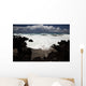 A wave breaks with lave rocks in the foreground Wall Mural