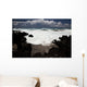 A wave breaks with lave rocks in the foreground Wall Mural