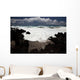A wave breaks with lave rocks in the foreground Wall Mural